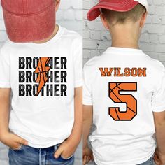 This cute Custom basketball brother Shirt is the cutest shirt to support his brother during his basketball season games! This shirt Features brother's baseball name and number on the back of his shirt, with Brother on the front with the basketball look. This Little kid brother basketball game shirt will sure to make his brother smile in support of his Big Brother Basketball Shirt. These Toddler boy basketball Sibling Tee comes in a variety of sizes and colors to show off his Basketball Bro Shirt to his brother and the crowd! ║ ABOUT OUR TODDLER, YOUTH AND INFANT SHIRTS ║ ◆ Sizes offered: See the Sizes we offer per the drop down menu ◆ Material: 100% Soft Cotton for the T-shirts and bodysuits ◆ Style: Unisex gender neutral clothing ◆ Care: Machine wash cold, inside out with like colors. Tum Basketball Brother Shirt, Sports Brother Shirt, Collegiate White Tops With Number Print, Collegiate White Top With Number Print, Personalized White Sporty T-shirt, Basketball Team Spirit T-shirt With Letter Print, White Number Print Top For Baseball Season, White Top With Number Print For Baseball Season, White Fan Apparel Top With Number Print