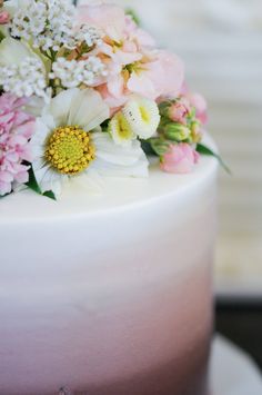 a white cake with pink and yellow flowers on top