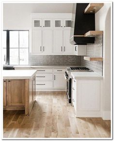 an empty kitchen with white cabinets and wood floors is pictured in this image from the front view