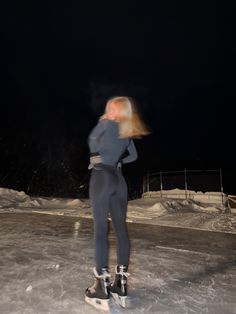 a woman riding skis on top of an ice covered slope in the snow at night