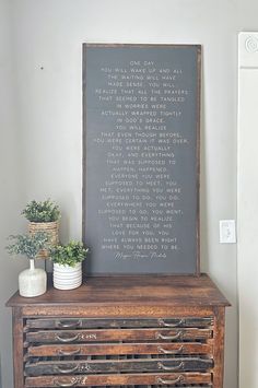 an old dresser has a chalkboard on it and some potted plants next to it