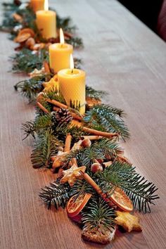 a long table is decorated with pine cones and candles