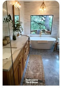 a bathroom with a tub, sink and large mirror in it's center area