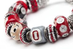 a red and silver beaded bracelet with the letter o on it