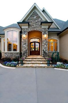 this is a nice house with stone and glass front doors that lead to the entry way