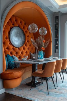 a dining room with orange chairs and a round table