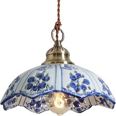 a blue and white light hanging from a ceiling fixture with an ornate design on it