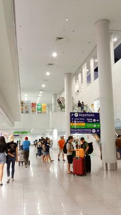 many people are walking through an airport with their luggage and baggage bags on the ground