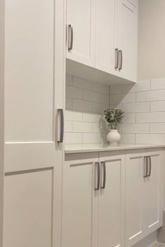 a kitchen with white cabinets and gray flooring