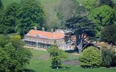 an aerial view of a large house in the middle of some trees and green grass