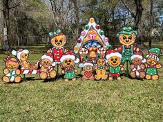 a group of teddy bears standing next to each other in front of a gingerbread house