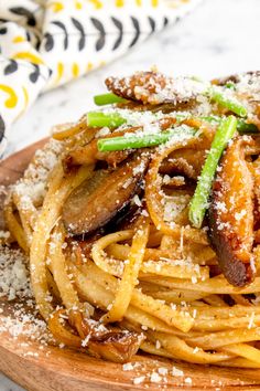 pasta with mushrooms and parmesan cheese on a wooden plate