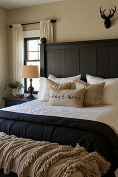 a bed with pillows and blankets on top of it in a bedroom next to a window