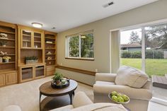 a living room filled with furniture and lots of windows