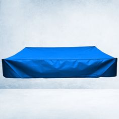 a blue table cover sitting on top of a white floor in front of a gray wall