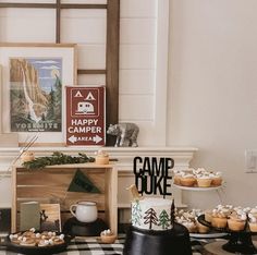 a table topped with cakes and cupcakes next to a fireplace