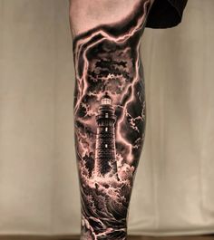 a man's leg with a lighthouse and storm coming in from the ocean on it