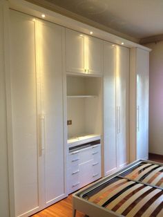 an empty bedroom with white closets and wooden floors