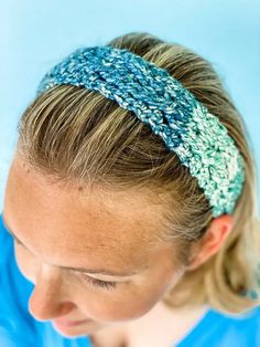 a woman wearing a headband made out of blue and white yarn with green trim