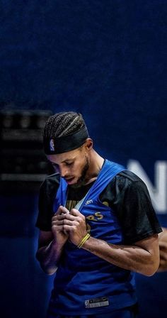 a male tennis player is looking down at his cell phone