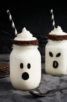 two mason jars decorated with frosting and faces