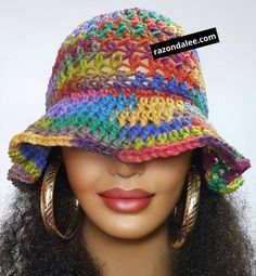 a close up of a mannequin head wearing a multicolored crocheted hat