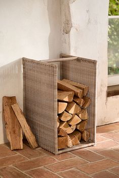 a stack of firewood sitting next to a window