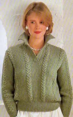 a woman standing in front of a white wall wearing a green sweater and pearls necklace