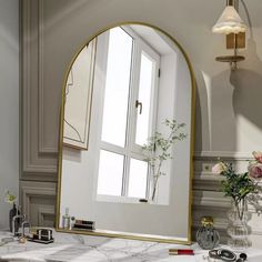 a bathroom vanity with a large mirror and flowers