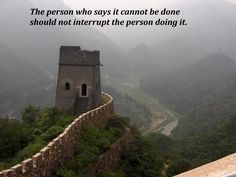 a person standing on top of a mountain with a quote above it that reads, the person who says it cannot be done should not interpret the person doing it