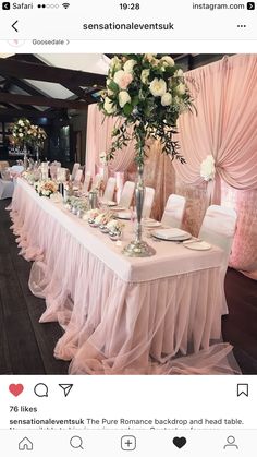 the table is set up for a wedding reception with pink linens and white flowers