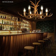 a dimly lit bar with wooden stools and deer antlers hanging from the ceiling