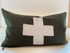 a green pillow with a white cross on it