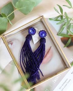 Add a touch of elegance to your outfit with these stunning matte blue beaded tassel earrings. The deep navy blue dangle earrings feature Swarovski crystal studs that add a hint of sparkle to your look. These bohemian-inspired fringe earrings are both trendy and chic, making them the perfect accessory for any occasion. Whether you're dressing up for a special event or adding a stylish touch to your everyday outfit, these seed bead earrings are sure to make a statement. Elevate your style with the Blue Dangle Tassel Earrings With Fringe, Blue Fringe Tassel Earrings For Party, Elegant Tassel Earrings With Round Dangling Beads, Chic Dangle Tassel Earrings As Gift, Elegant Beaded Fringe Jewelry, Chic Handmade Earrings For Evening, Blue Fringe Dangle Chandelier Earrings, Tassel Drop Earrings For Evening, Blue Long Drop Tassel Jewelry