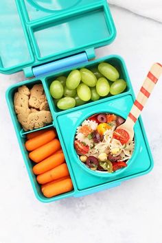 a blue lunch box with carrots, grapes, crackers and salad in it