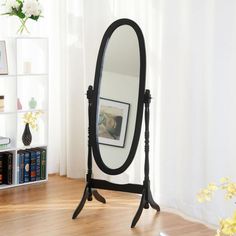 a mirror sitting on top of a wooden floor next to a book shelf filled with books