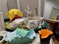 there are many different types of pottery on the table together, including one large bowl and two smaller bowls