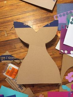 the paper is cut out to look like a woman's torso and breast on top of other pieces of cardboard