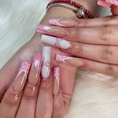 a woman's hands with pink and white nail designs on their nails, one is holding the other