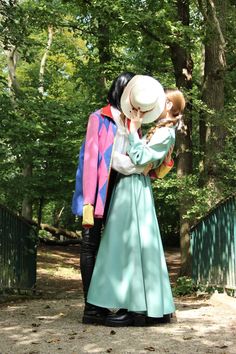 a man and woman dressed in costume standing next to each other on a dirt road