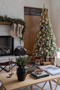 a living room filled with furniture and a christmas tree in front of a fire place