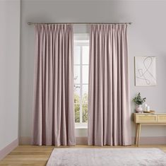 a living room with a white rug and pink curtains