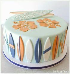 a surfboard cake is decorated with fondant and frosting