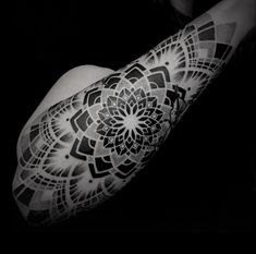 a woman's arm with an intricate tattoo design on the left side of her arm