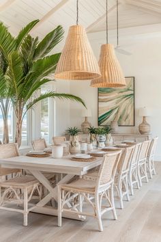 a dining room table and chairs in front of a palm tree with two hanging lights