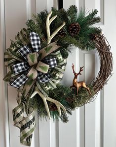 a christmas wreath hanging on the front door with deer head and antlers attached to it