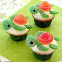 three cupcakes with white frosting and red flowers on them, sitting on top of a green napkin