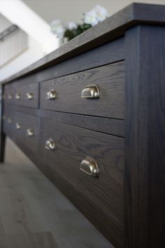 a close up of a dresser with drawers and knobs on the bottom half of it