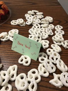 a table topped with lots of donuts covered in white frosting next to a sign