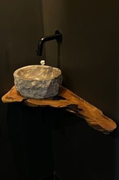 a bathroom sink made out of wood with a black faucet next to it